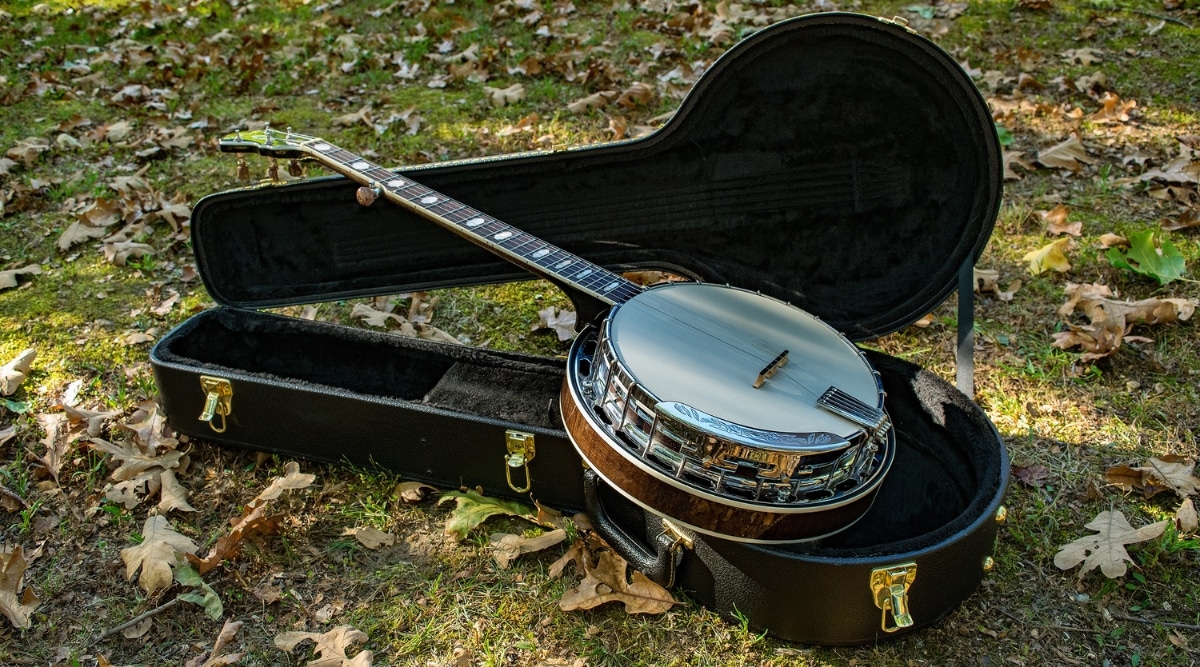 Valley Folk and Wine Festival. Banjo on the ground outdoors during festival with grass growing beneath it.