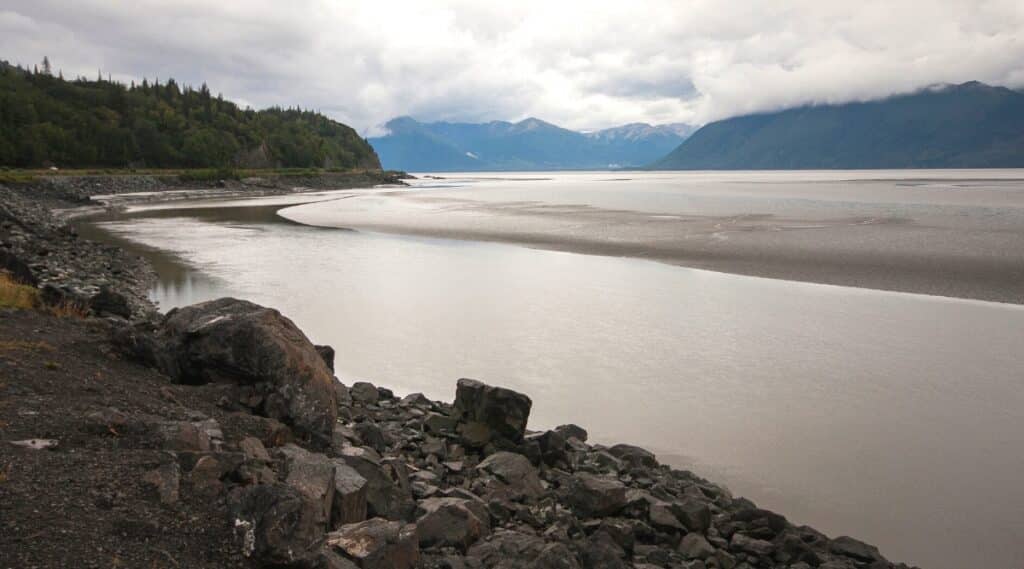 The Black Sand Beach in Prince William Sound, Alaska is a remote and rugged dark volcanic sand beach surrounded by stunning glaciers, steep cliffs and dense forests.