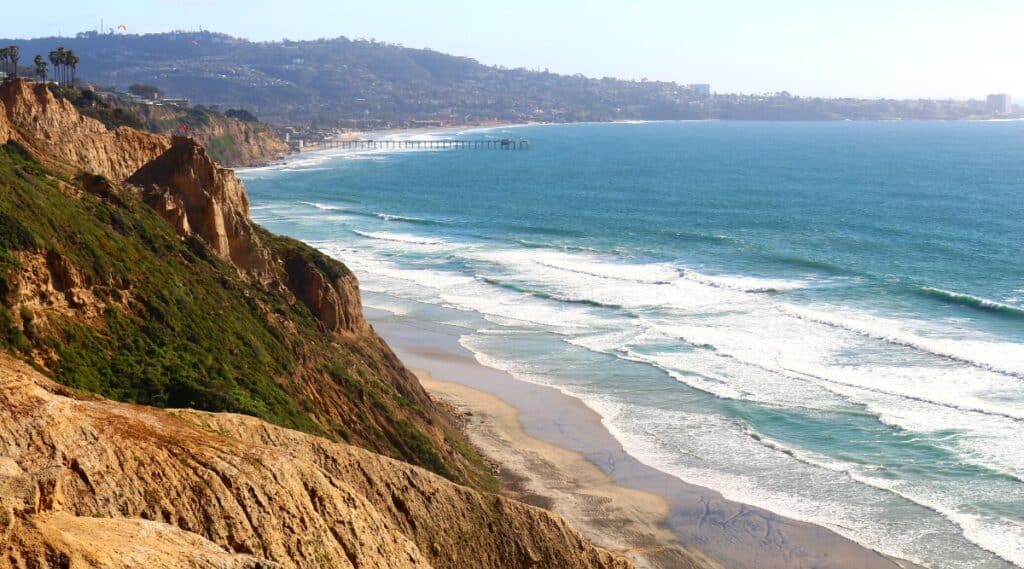 Black's Beach in San Diego, California is a secluded beach located beneath the 300-foot sea cliffs of Torrey Pines, famous for its stunning black sand.
