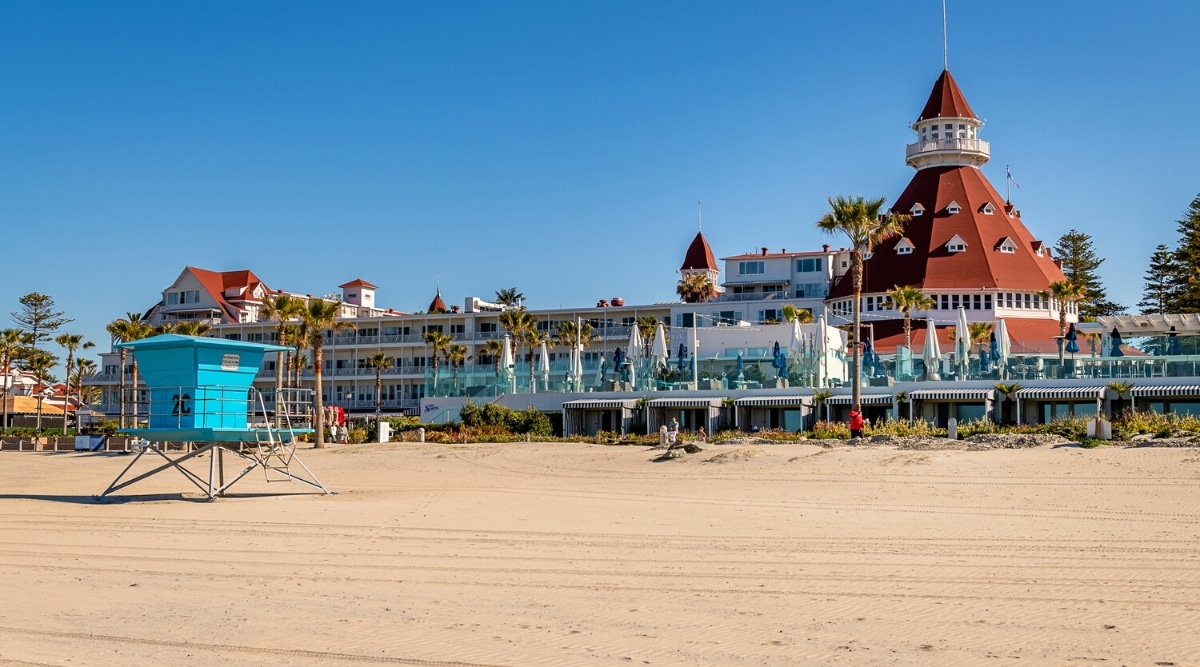 Coronado Beach, located in San Diego, California, is a stunning beach known for its sparkling golden sand, clear waters, and picturesque scenery. Close-up of the historic Red Roof Hotel Del Coronado with panoramic ocean views.
