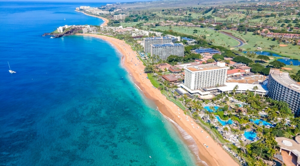 Kaanapali Beach in Hawaii is a stunning beach with soft golden sand, crystal clear water, and excellent snorkeling opportunities. The beach is surrounded by upscale resorts.