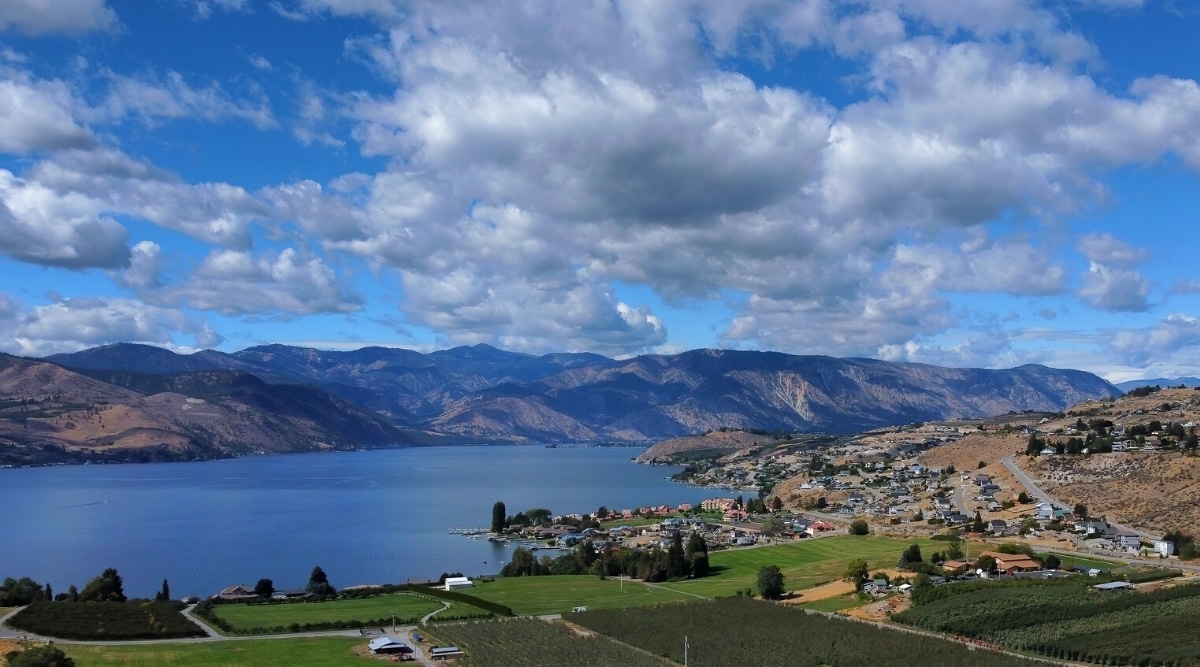 Lake Chelan is a beautiful, narrow, and deep freshwater lake in Washington, known for its crystal-clear water, stunning mountain views. The lake has blue water surrounded by mountains and villages.