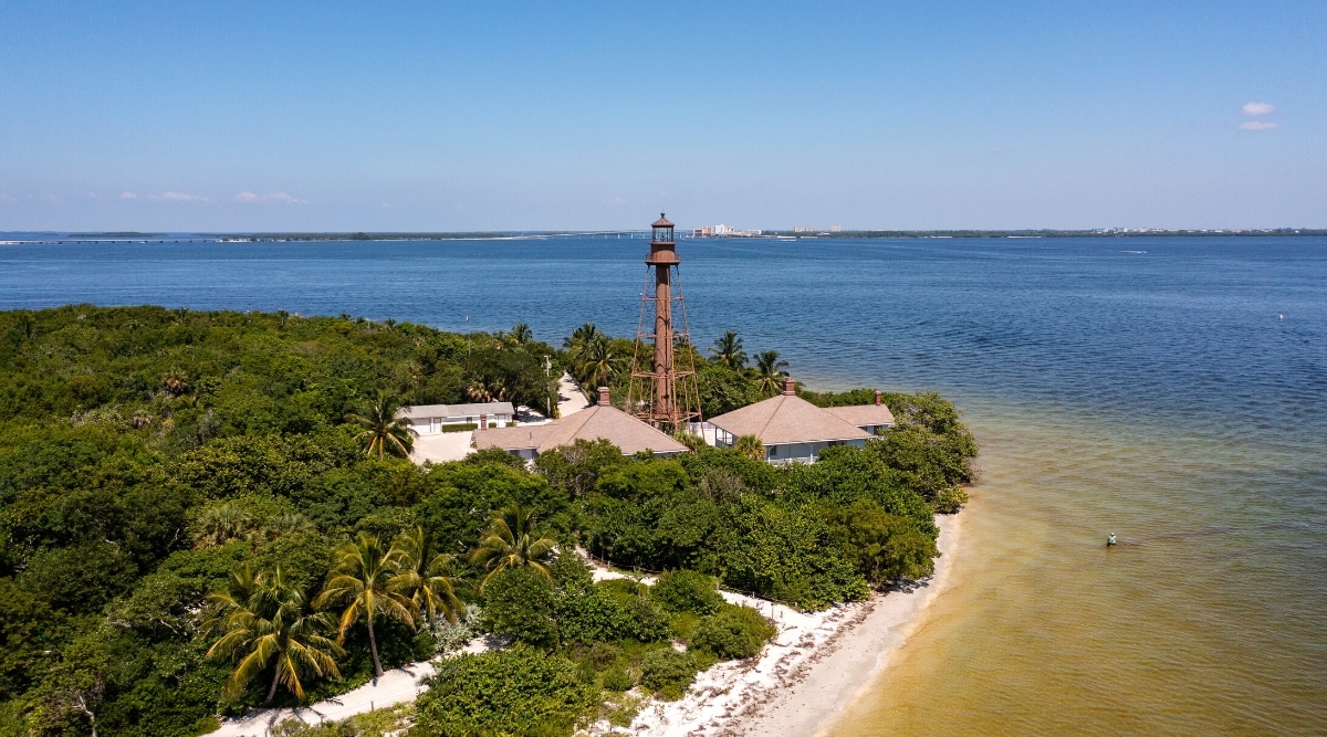 Lighthouse Beach Park is a public beach located on Sanibel Island in Florida, USA. The beach is known for its serene and picturesque atmosphere, soft white sand and clear turquoise water. Aerial view of the white sandy beach with blue waters and the historic Sanibel Lighthouse.