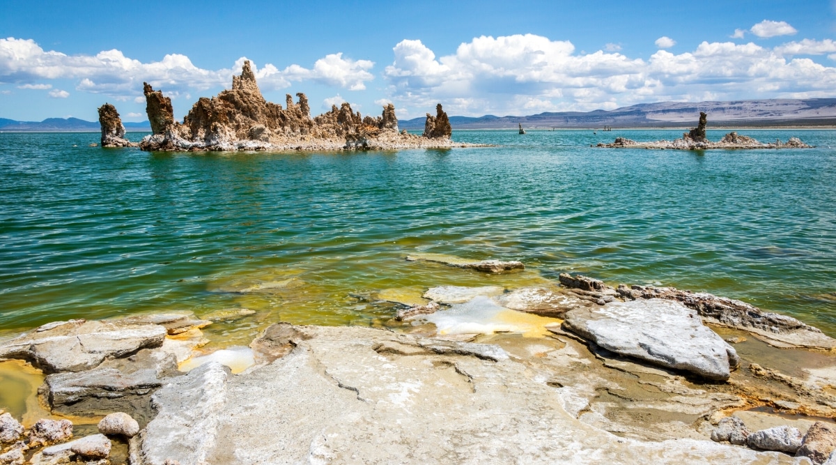 Mono Lake is a unique and ancient saline soda lake in California. The lakes have crystalline emerald waters and stunning tufa towers, limestone formations rising out of the water.
