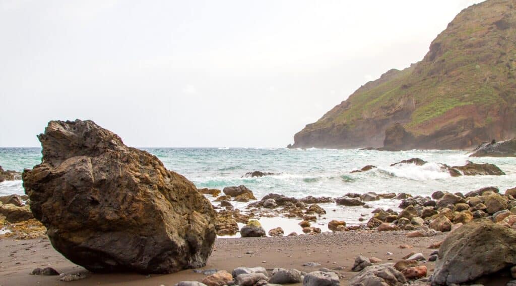 Playa Roque Bermejo is a secluded black sand beach located on the northwestern coast of the island of Tenerife in Spain. It has crystal clear waters, high cliffs and impressive rock formations.