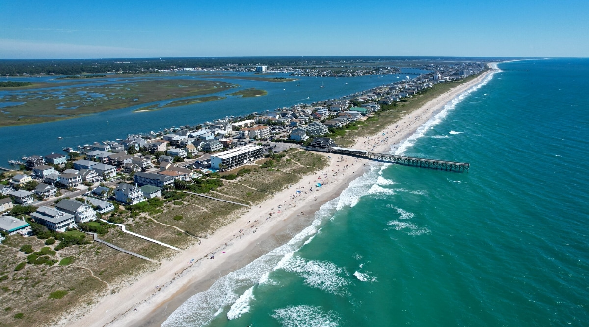 Wrightsville Beach is a popular beach town located in New Hanover County, North Carolina, USA. The beach is known for its crystal clear waters, wide sandy shoreline and long pier with scenic views. The beach is surrounded by hotels, restaurants and shops.