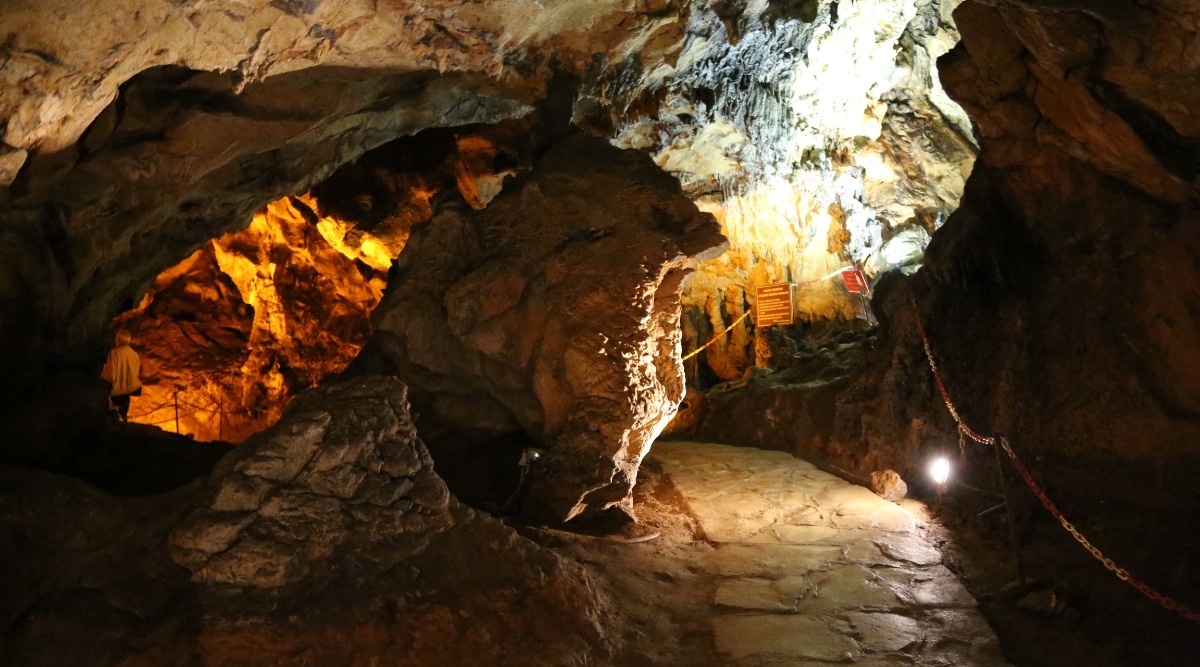 A photograph capturing the interior of Mark Twain Cave in Missouri. The image showcases the cave's geological formations, including stalactites and stalagmites, illuminated by artificial lighting. 