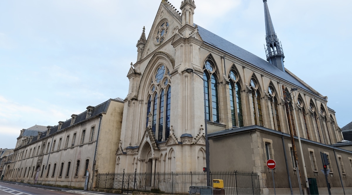 The historic Basilique Saint-Remi in Reims France, photographed from the street on a cloudy day.