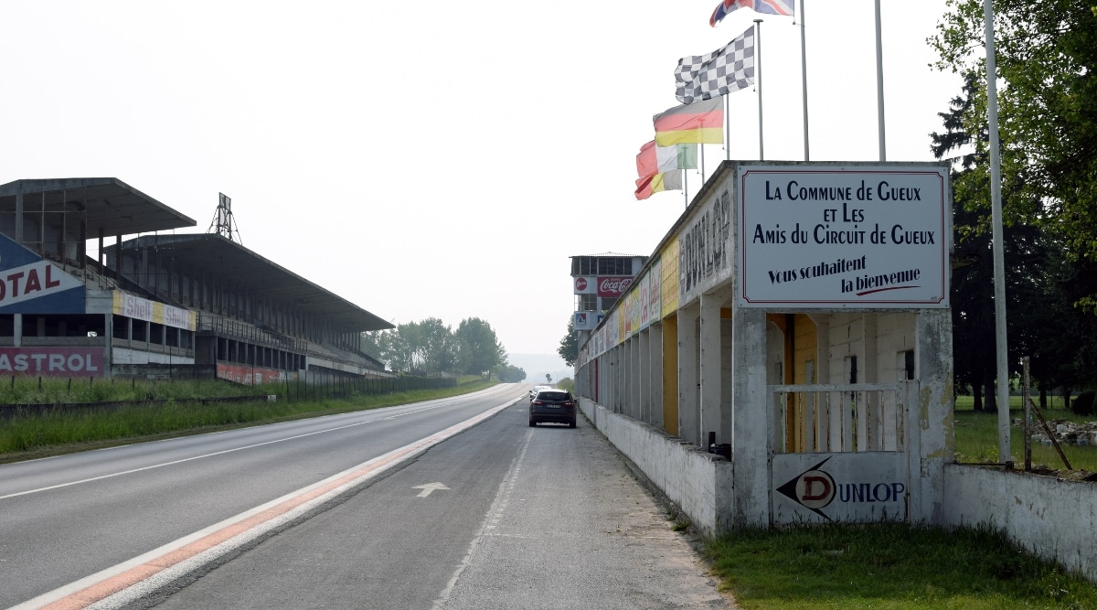 The historic Reims-Gueux circuit photographed on a cloudy day. A deserted road with a single car.