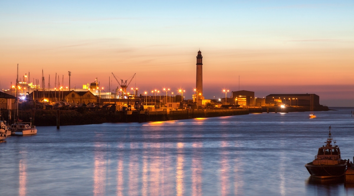 Port du Bassin du Commerce in Dunkirk France, at sunset, with the lights reflecting off the water.