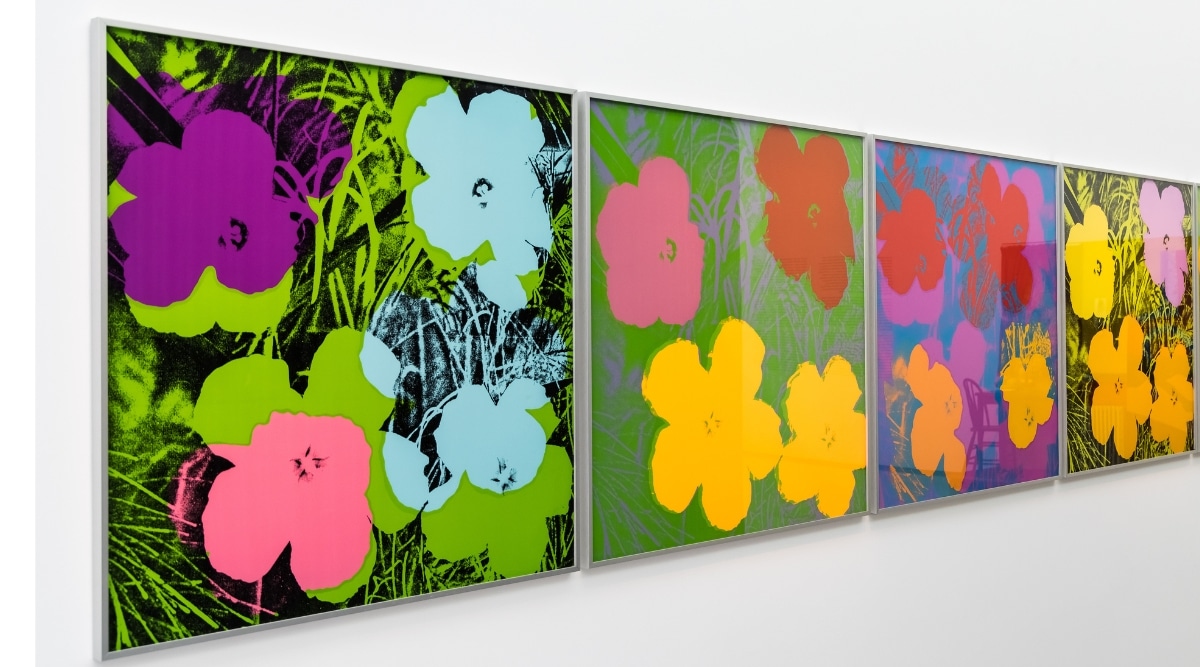 Close up display of Andy Warhol paintings of flowers in a contemporary style.