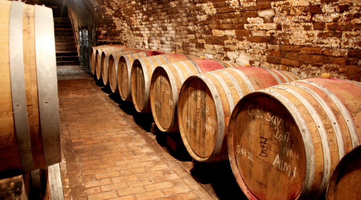 Cave Historique des Hospices Civils de Strasbourg in France. The underground cellar, steeped in centuries of history, is adorned with ancient wine barrels. Rows of meticulously stacked wine barrels. The ambient lighting casts a warm glow on the wooden casks.