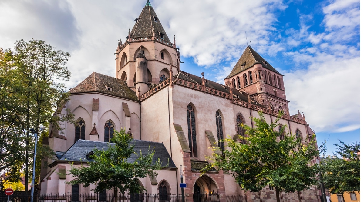 The exterior of the Eglise Saint-Thomas in Strasbourg, France on a clear summer day.