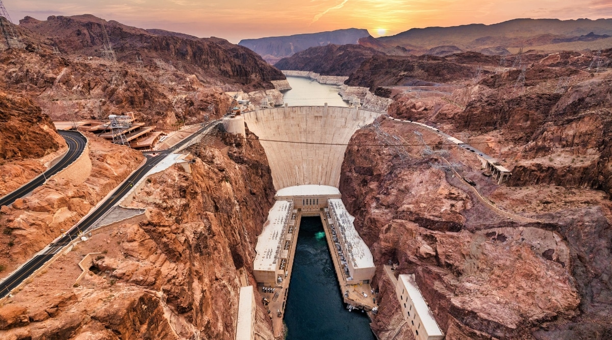This captivating image showcases the iconic Hoover Dam, a marvel of engineering and a symbol of American innovation. The dam spans the mighty Colorado River, its colossal concrete structure standing in stark contrast to the rugged desert landscape that surrounds it.