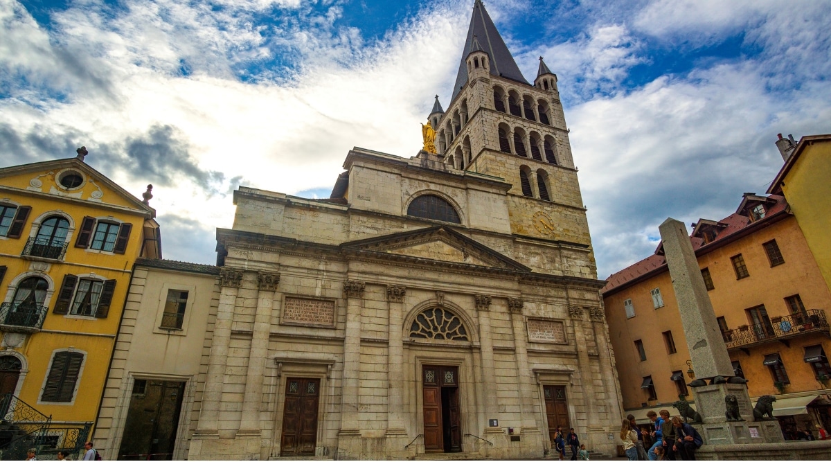 A captivating photograph of the Eglise Notre Dame de Liesse, a splendid Gothic church. The image showcases the intricate architectural details of the church's façade, including its ornate stained glass windows, pointed arches, and delicate stonework.