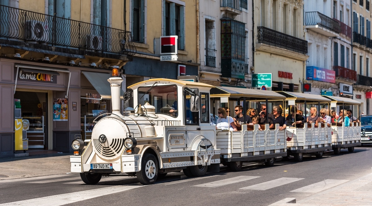 The Petite Train is full of tourists and travels through the historical streets of the city. The Petite Train, or "Little Train," is a charming tourist attraction which consists of a small, open-sided train-like vehicle, brightly colored, designed for guided tours.