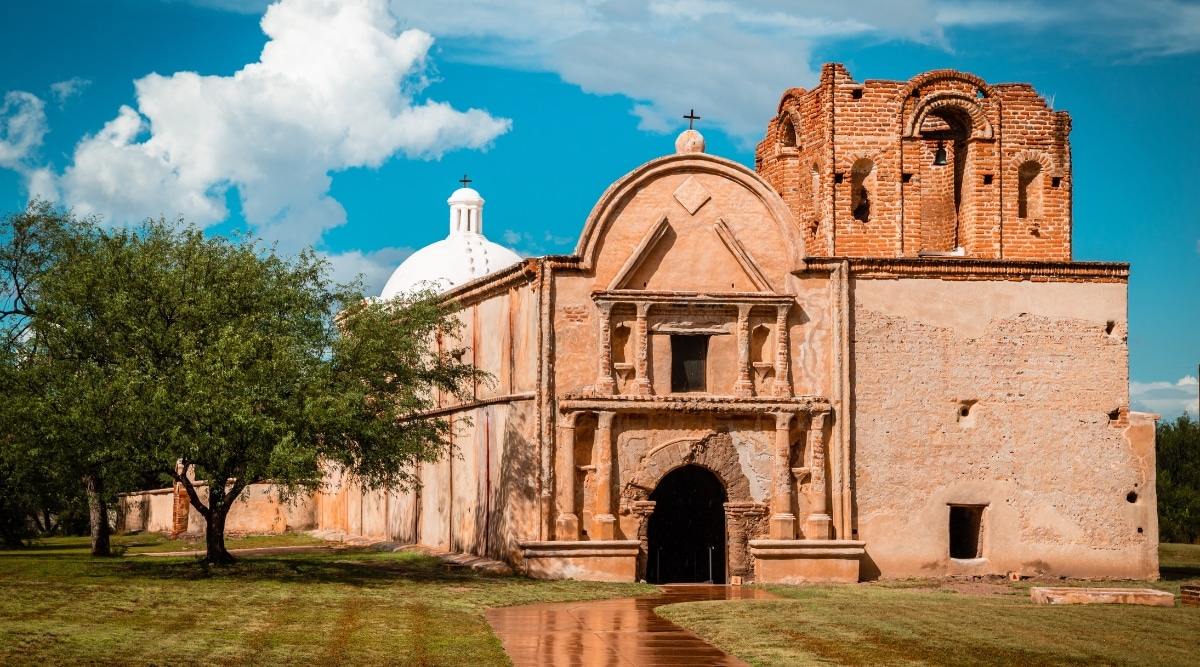 A captivating view of the Tumacacori National Historical Park. The photo shows the well-preserved ruins of the Spanish mission, built of sand-colored stone. The stone archways, bell tower, and intricate details of the mission architecture stand as a testament to centuries of history.