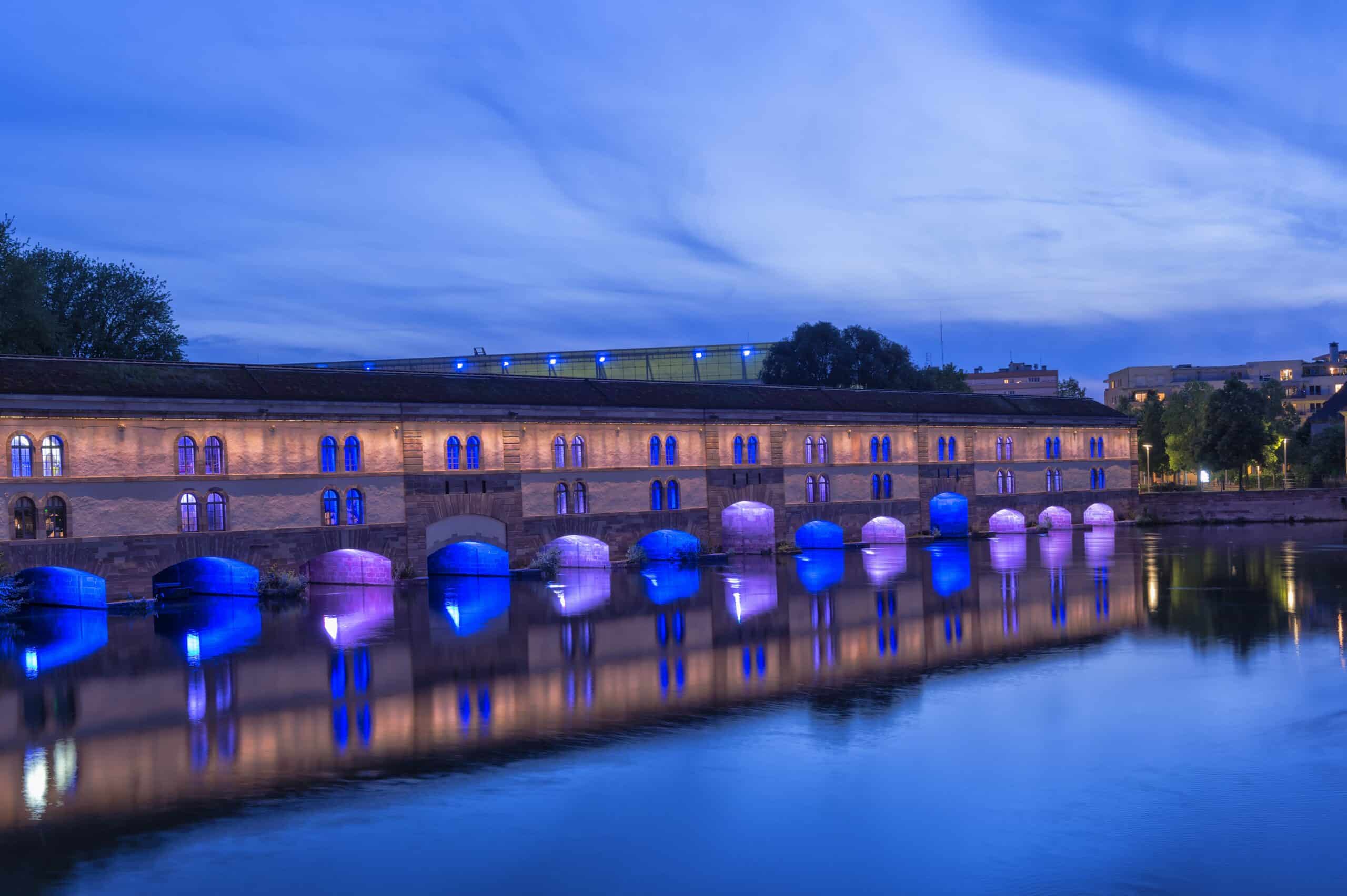 The illuminated Vauban Dam at twilight in Strasbourg France.