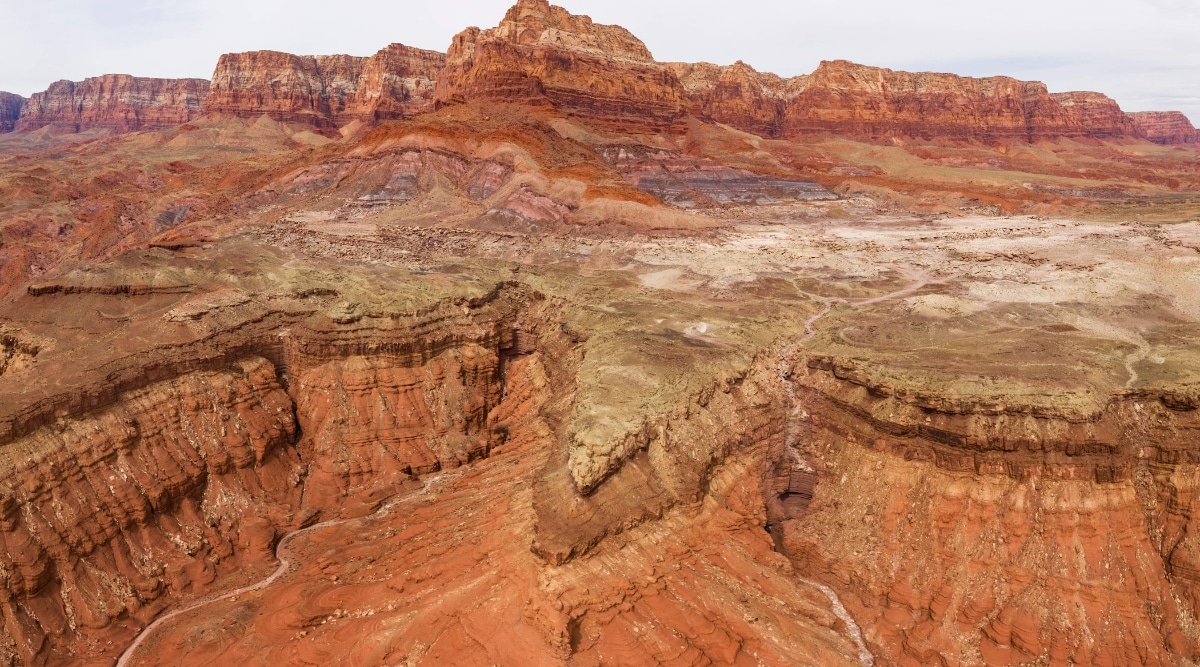 The photo shows off-road conditions near Vermilion Cliffs. The Vermilion Cliffs, characterized by their towering red, orange, and white sedimentary rock layers.