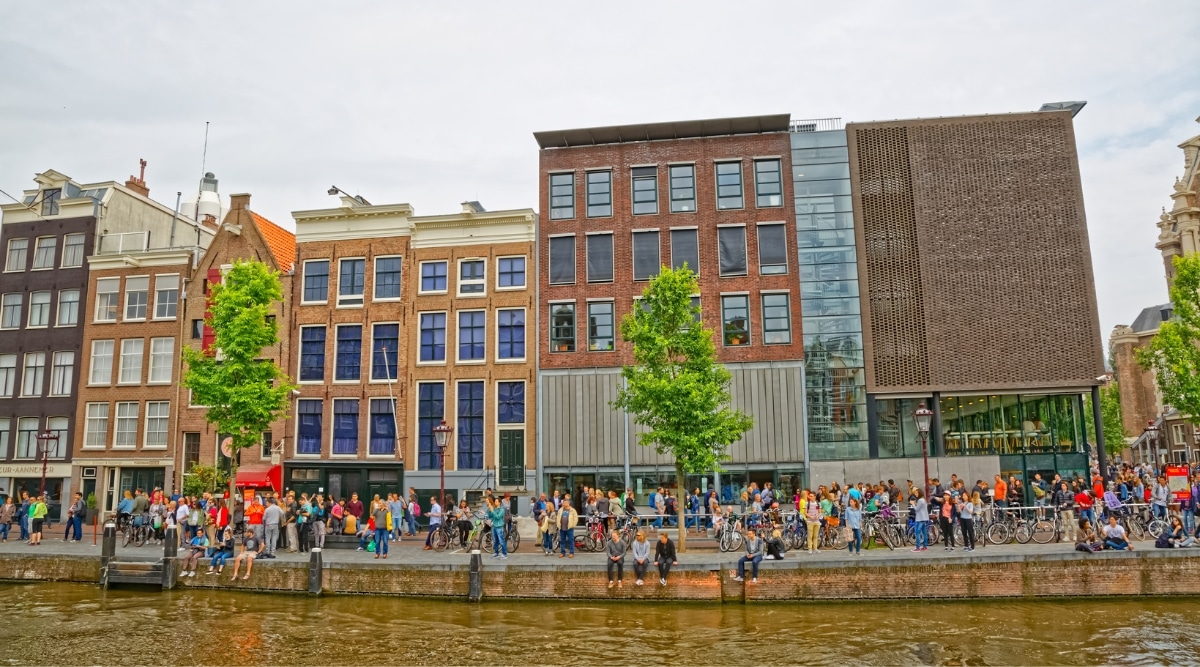 A poignant photograph capturing the exterior of the Anne Frank House, a historic landmark in Amsterdam. The image showcases the iconic canal-side facade of the preserved house. The classic Dutch architecture, with its distinctive gabled roof and large windows.