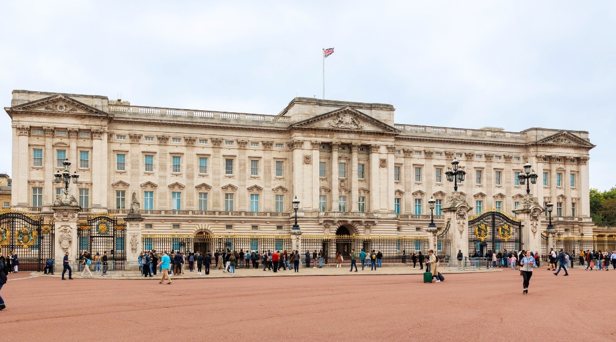 Buckingham Palace, the iconic residence of the British monarch in London. The image showcases the majestic facade of the palace, adorned with intricate architectural details and the iconic balcony. Classic windows and decorative features. The Union Jack flag proudly flutters against the backdrop of the palace's neoclassical architecture.