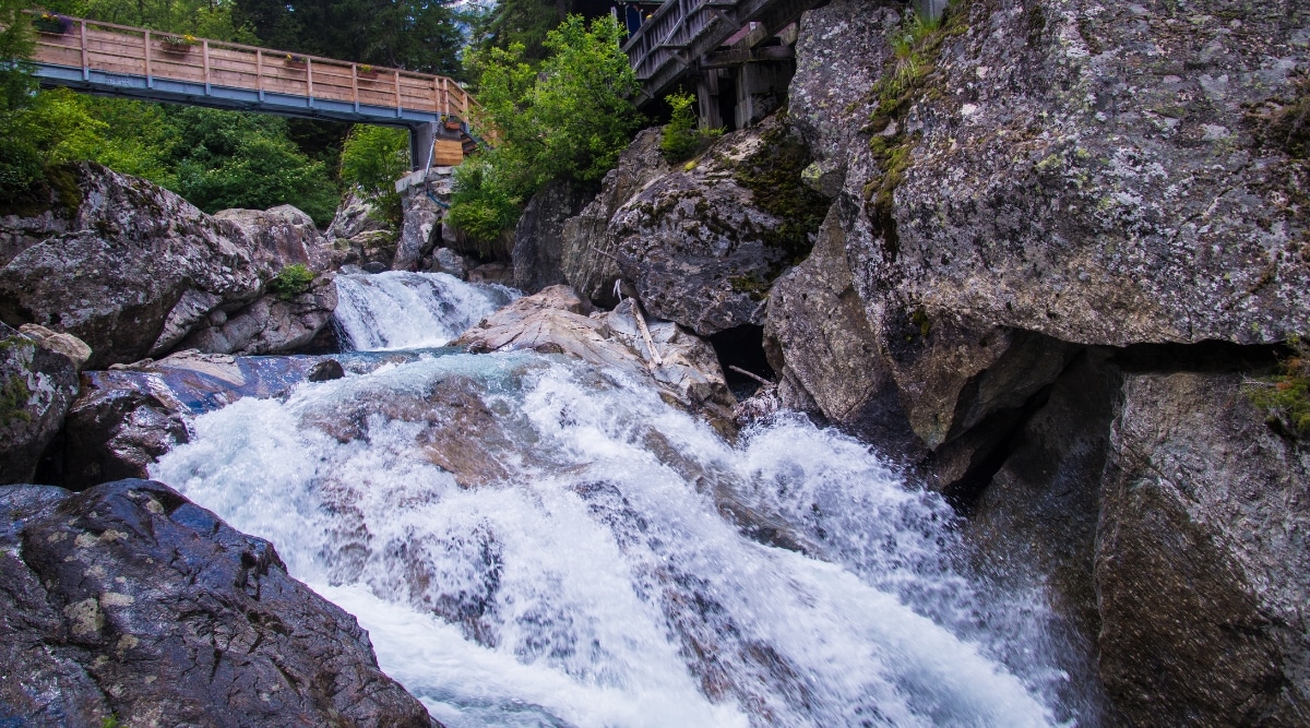 Cascade du Bérard, a picturesque waterfall located just outside Chamonix, France. Nestled in a pristine alpine setting, the waterfall descends. The crystal-clear water cascades gracefully over the rocks.