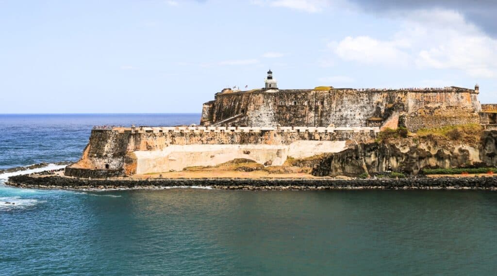 A photograph capturing Castillo San Felipe del Morro in Puerto Rico. The image illustrates the historic fortress situated against the coastline. The structure exhibits characteristic elements of Spanish colonial military architecture, featuring sturdy walls and lookout towers.