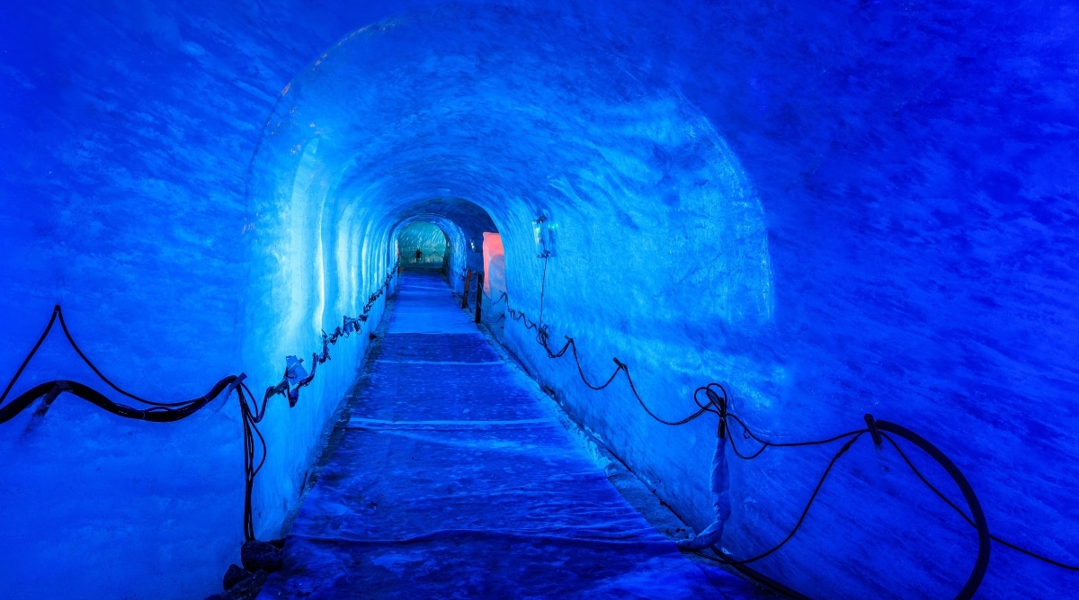 An extraordinary image captures the mesmerizing interior of the Mer de Glace Glacier in Chamonix, France. Deep within the glacier's icy caverns, a surreal world unfolds. Walls of ancient blue ice surround visitors, revealing the glacier's intricate layers formed over centuries.
