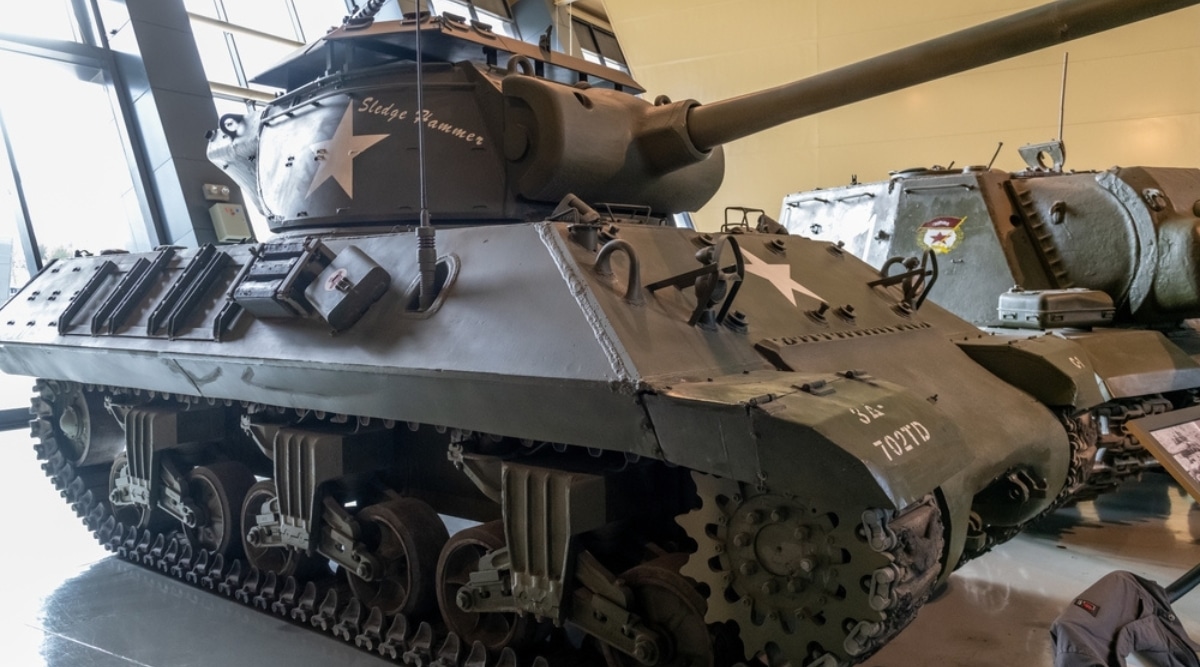 Close-up of a large tank in MM Park France. The tank is large, dark green and black with the emblems of the yellow stars and various inscriptions.