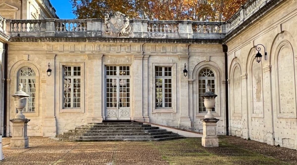The Musee Calvet, located in Avignon, France, is an elegant and historic art museum housed in a majestic 18th-century building. The exterior of the museum exudes classical charm with its stone façade adorned with ornate architectural details. Tall white windows against the background of beige-white walls look charming, adding a romantic charm.