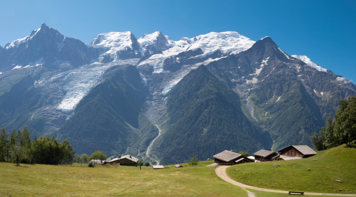 Parc de Merlet in Chamonix, France. The park, nestled in the French Alps, is surrounded by majestic mountain peaks and lush alpine meadows. The distant view showcases the immense scale of the surrounding mountains, emphasizing the park's integration with the awe-inspiring alpine environment.