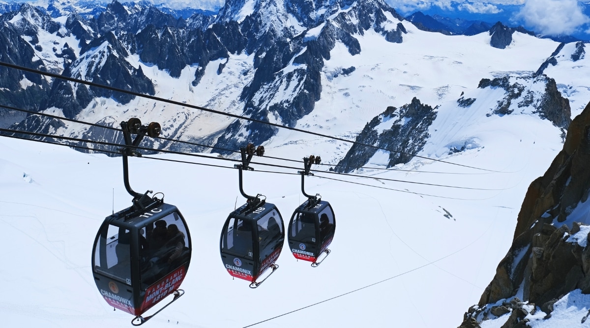 An exhilarating image captures the panoramic ascent via the lift to the mountain Pointe Helbronner in Chamonix, France. The cable car system, suspended against the backdrop of the French Alps, provides a thrilling journey to the summit.