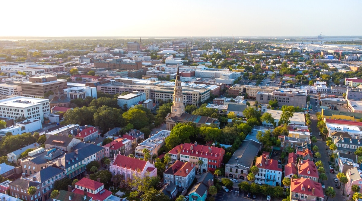 An aerial perspective capturing the cityscape of Charleston, South Carolina. The image provides an overview of the urban layout, showcasing buildings, streets, and water features. 