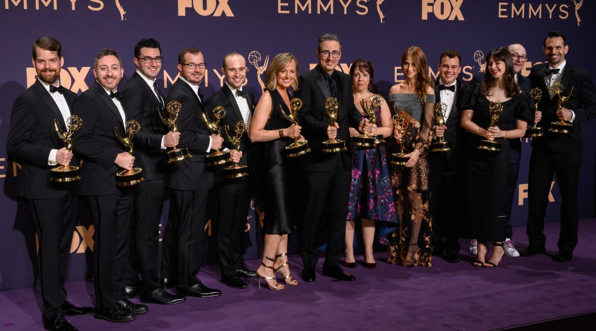 A photograph capturing actors and actresses holding Emmy Awards statues, posing for a photo. The image showcases the individuals in formal attire, set against a backdrop that suggests a formal event venue in Los Angeles.