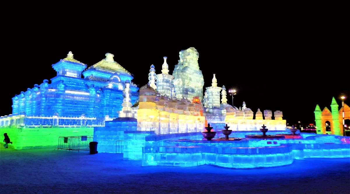 The photograph depicts the annual Harbin International Ice and Snow Festival in Harbin, China. Sculpted ice castles and palaces are showcased as prominent features of the festival. The structures are meticulously crafted from ice.