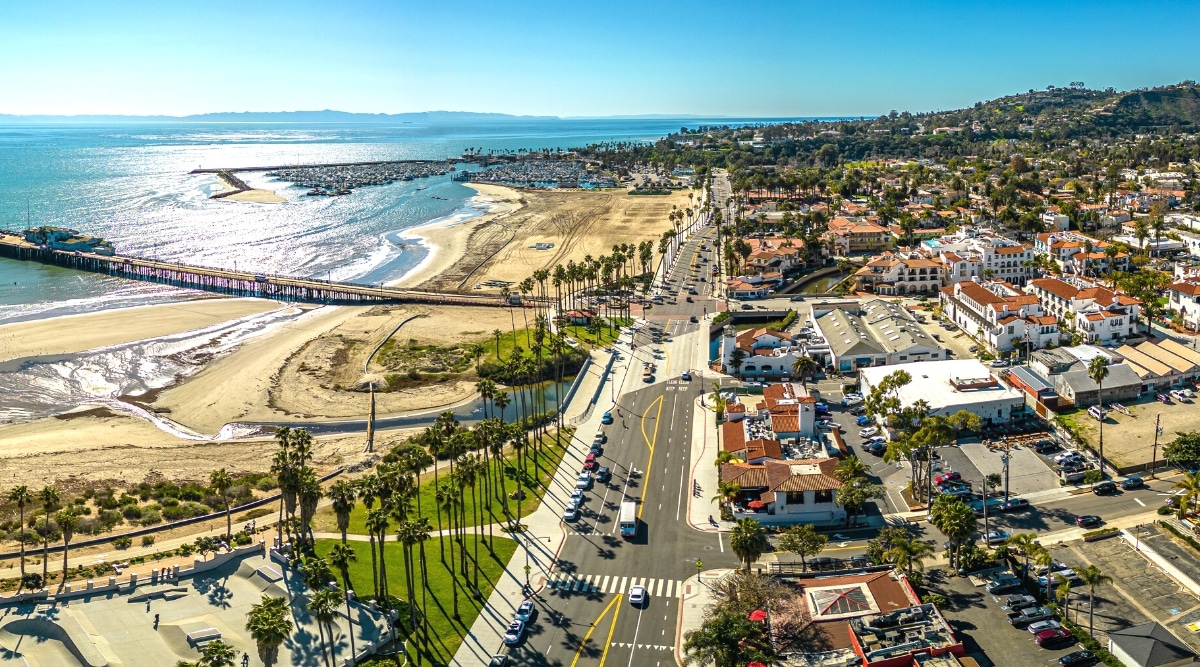 A top view capturing the expanse of Ocean Beach and the city of Santa Barbara. The photograph depicts the coastal area with the Pacific Ocean extending to the horizon and the cityscape in the background. 