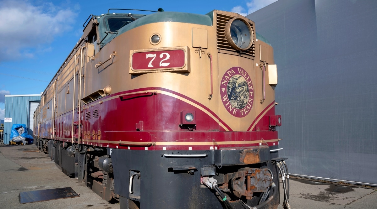 An image capturing the Napa Valley Wine Train, a privately operated excursion train that travels between Napa and St. Helena, California. The train's exterior is visible, showcasing its design and branding.