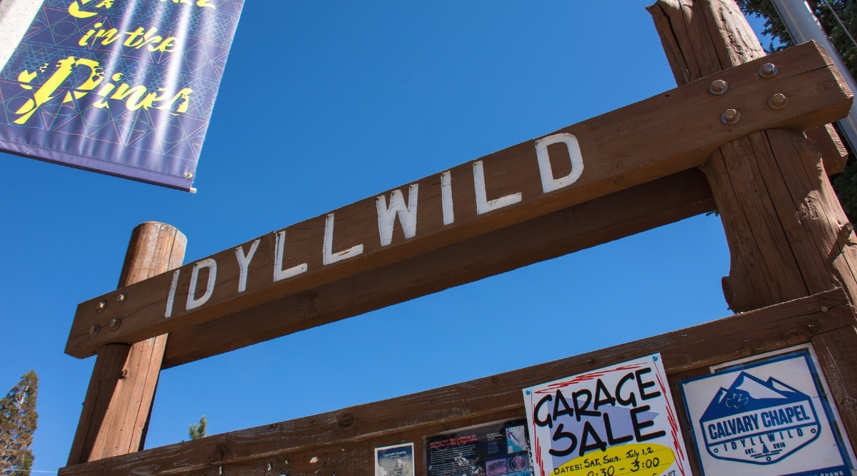 A close-up photograph capturing an inscription sign in Idyllwild. The image showcases a wooden sign with the inscription 'Idyllwild' in a straightforward manner. The sign features a basic design, displaying the town's name with no distinctive embellishments.