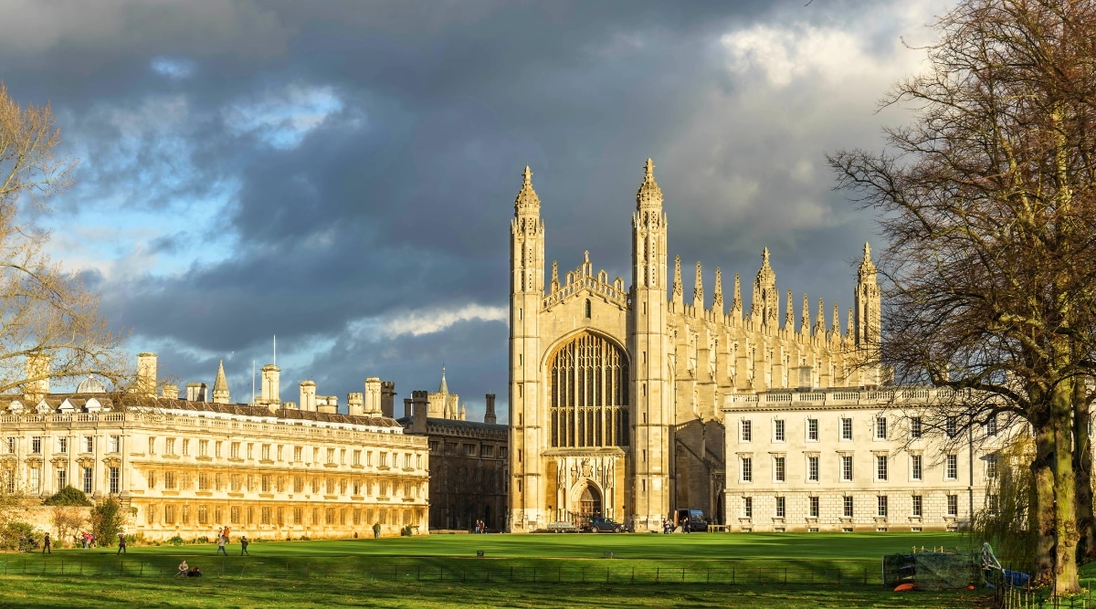 A photograph capturing Clare and King's College in Cambridge on a cloudy day. The image showcases the architectural features of the colleges against a backdrop of clouds. The historic structures exhibit the classic design prevalent in Cambridge's academic landscape.