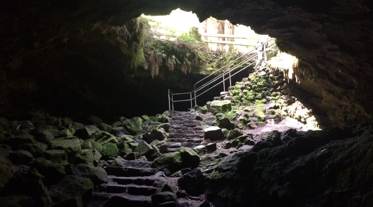 A view from the cave interior facing towards the entrance of Dunmore Cave in Kilkenny, Ireland. The image captures a perspective of the cave's interior featuring stairs and a notable presence of sharp stones in the vicinity. 