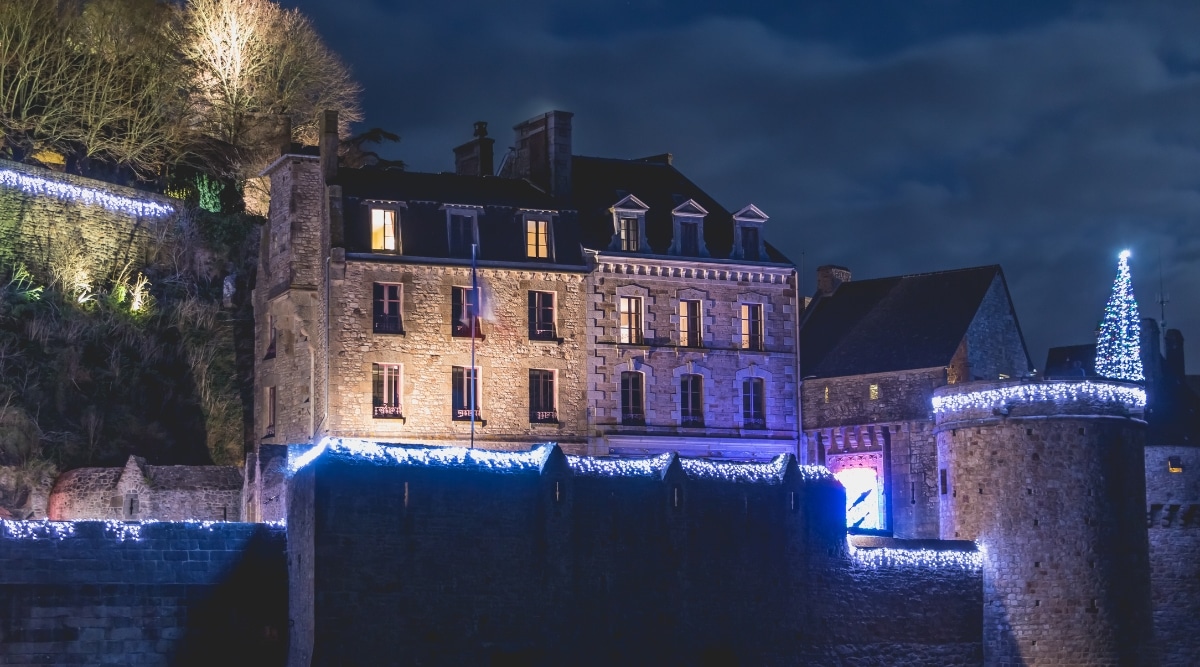 Mont Saint Michel during the holiday season at night, lit up with lights.