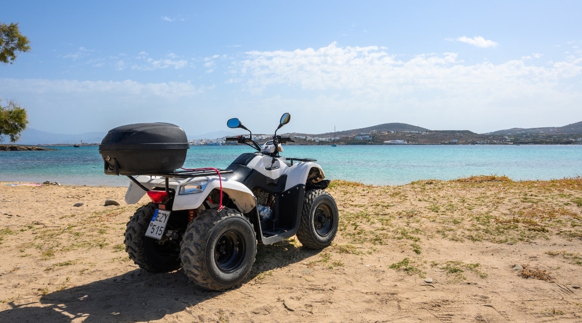 A photograph capturing a quad parked at Kolymbithres Beach on Paros island in the Cyclades, Greece. The image showcases the beach environment with the parked quad, providing a visual reference for the recreational activities available in the area.