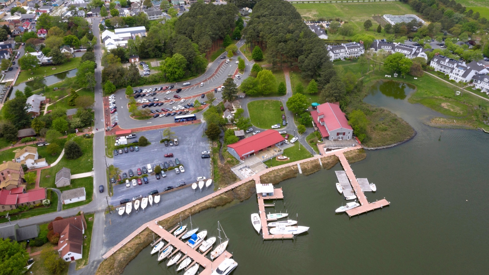 An aerial view panorama capturing ships docked along the waterfront in St. Michaels, Maryland, situated in Chesapeake Bay. The image displays an array of vessels along the docks, showcasing maritime activity in the area.