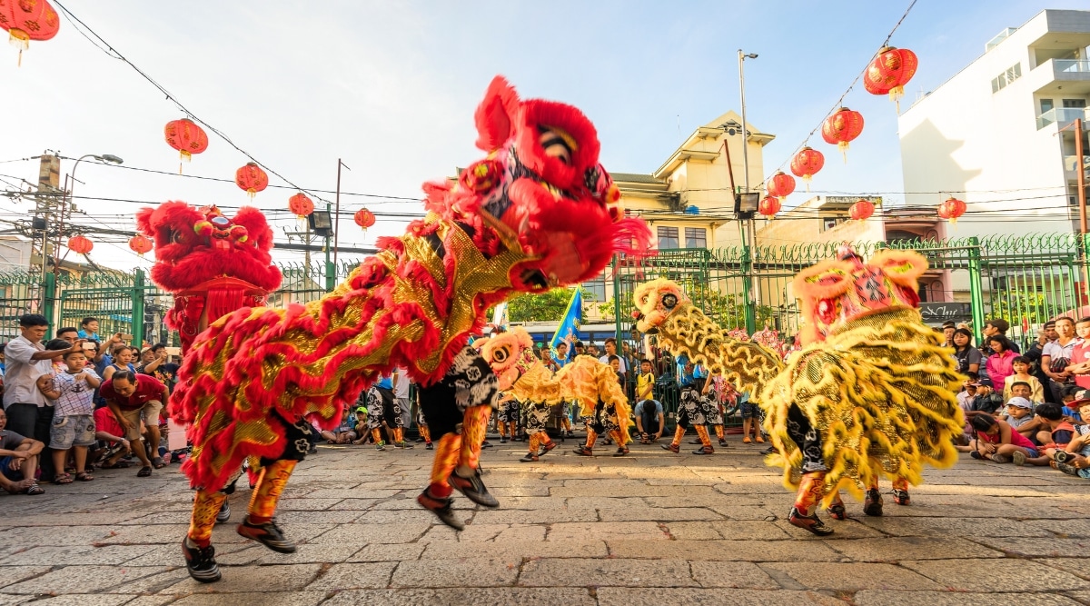 A photograph capturing Tết Nguyên Đán festivities in Vietnam. The image features individuals adorned in various colored outfits, predominantly in red jelly clothes, engaging in a performance.