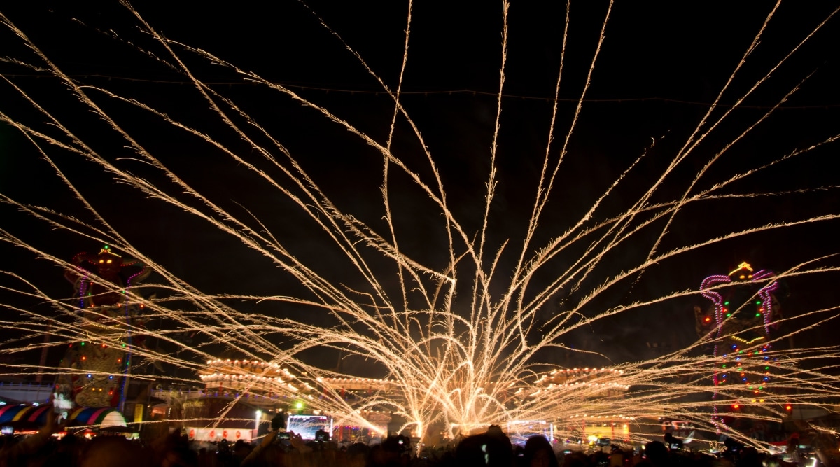 A photograph capturing a vibrant display of fireworks at the Yangshuo Beehive Fireworks Festival. The image features a multitude of fireworks illuminating the night sky.