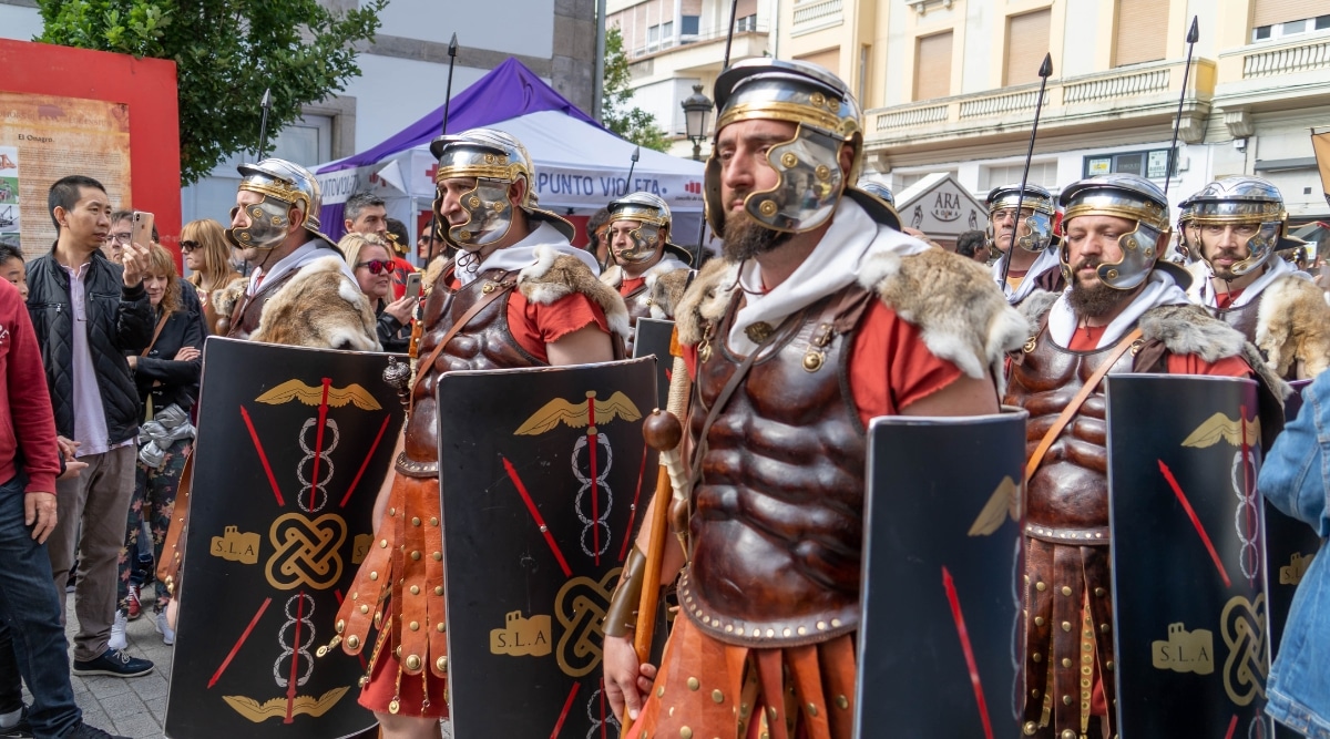 An image capturing the gladiatorial festival during Les Grands Jeux Romains in Nimes, France. The scene features participants in historical Roman attire engaging. The festival showcases aspects of Roman culture, including combat demonstrations and other historical performances.