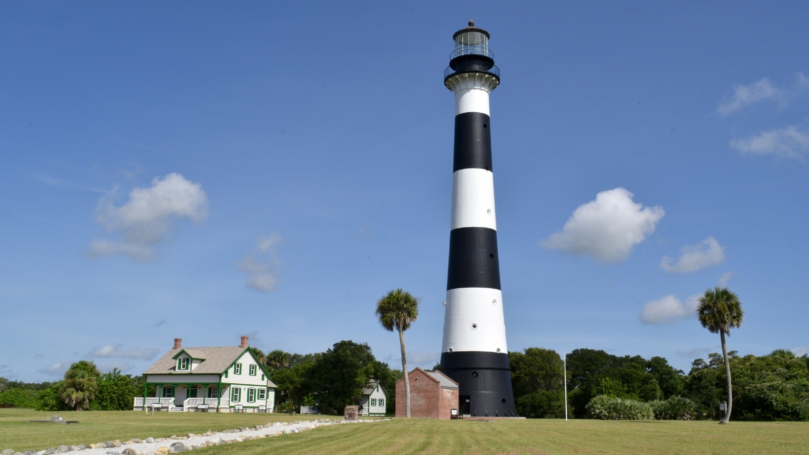 A photograph capturing Cocoa Beach, Florida, featuring the Canaveral Lighthouse. The image depicts the coastal area with the lighthouse standing prominently against the skyline.