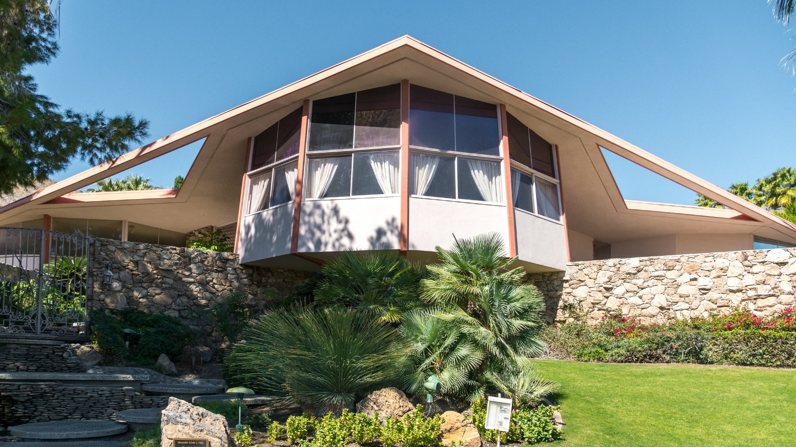 A photograph depicting the Elvis Honeymoon House in Palm Springs, California. The image showcases the exterior of the residence, known for its historical association with Elvis Presley.