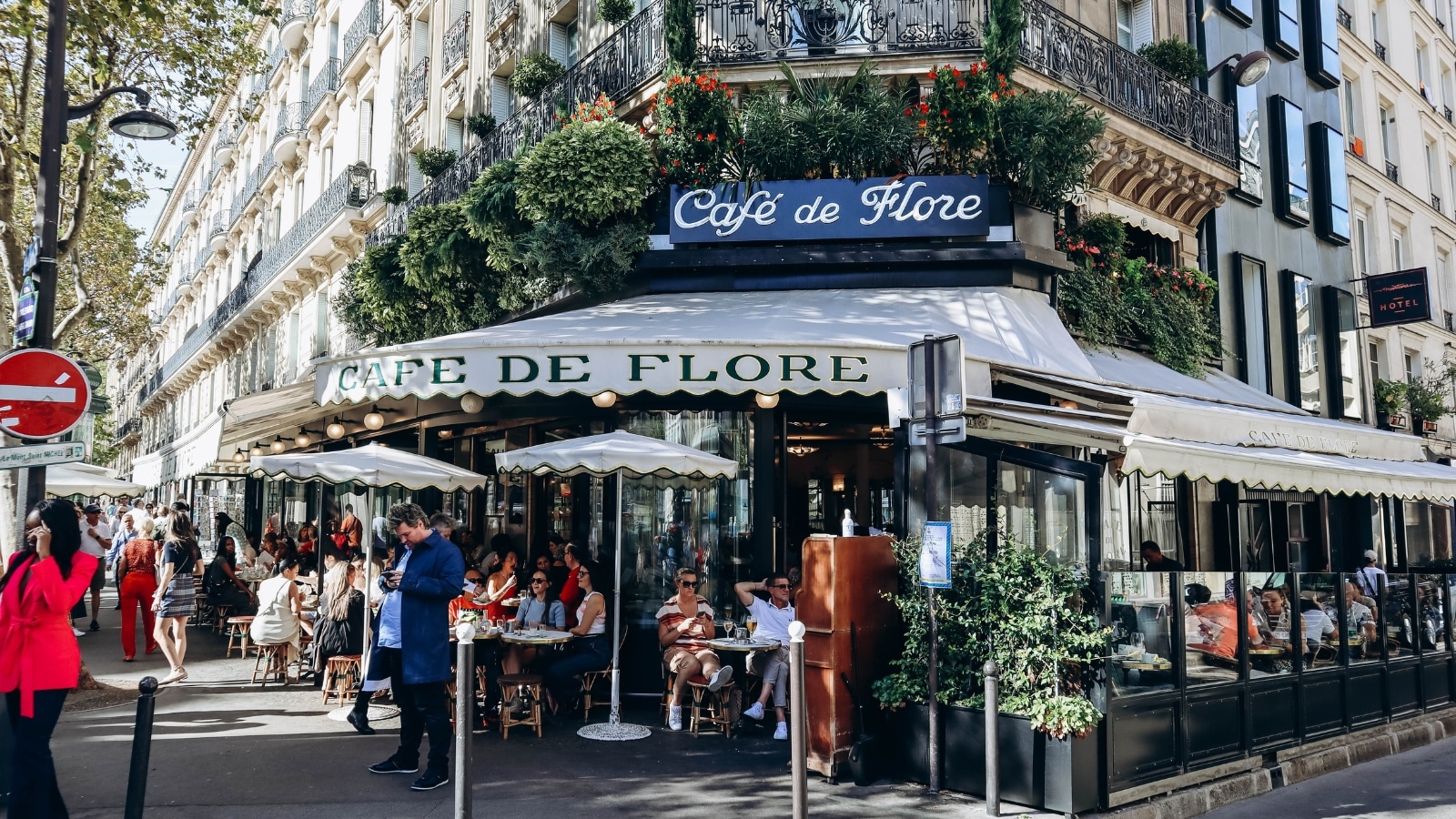 A photograph capturing the facade of the renowned Cafe de Flore on Boulevard Saint-Germain. The image highlights the exterior of the establishment, featuring architectural elements consistent with traditional Parisian design. 