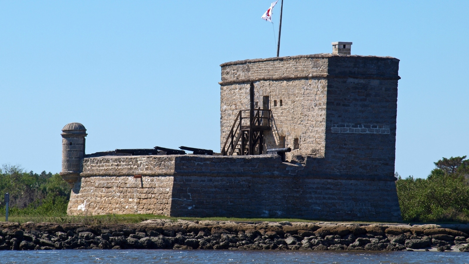 The image shows Fort Matanzas National Park, featuring the historical fort structure surrounded by natural landscape.